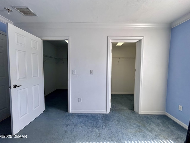 unfurnished bedroom with carpet, visible vents, a spacious closet, and a closet