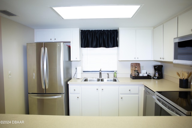 kitchen with white cabinets, appliances with stainless steel finishes, and sink