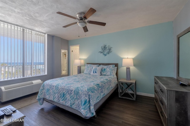 935 S Atlantic Ave Unit 509, Daytona Beach, FL 32118 - bedroom featuring baseboards, a wall unit AC, a ceiling fan, and dark wood finished floors