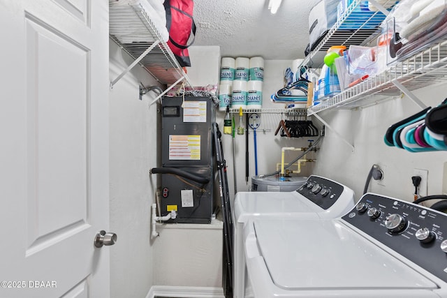 laundry room featuring laundry area, baseboards, a textured ceiling, and independent washer and dryer