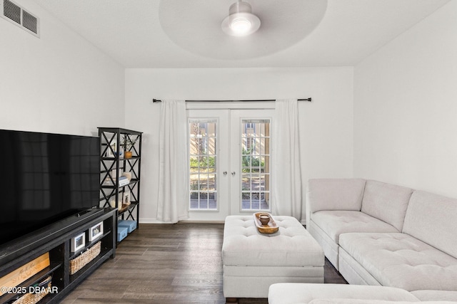 living room with dark wood-style floors, french doors, visible vents, and ceiling fan