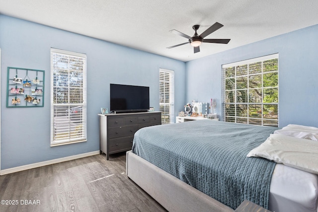 bedroom featuring a textured ceiling, ceiling fan, wood finished floors, and baseboards