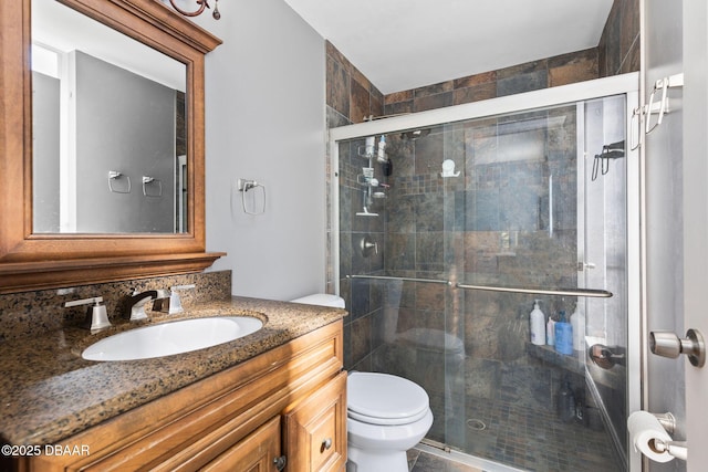 full bath featuring a stall shower, vanity, and toilet