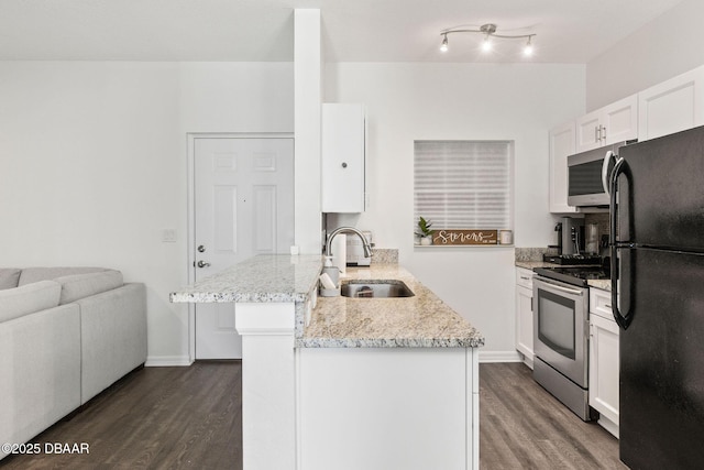 kitchen with a peninsula, a sink, white cabinets, appliances with stainless steel finishes, and dark wood finished floors