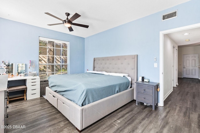 bedroom featuring a ceiling fan, visible vents, baseboards, and wood finished floors