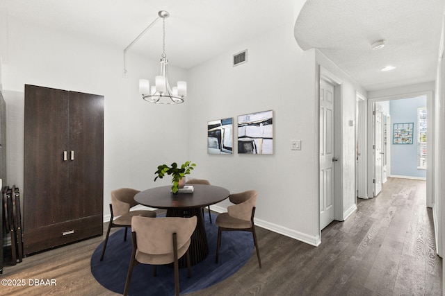 dining space featuring an inviting chandelier, dark wood finished floors, visible vents, and baseboards