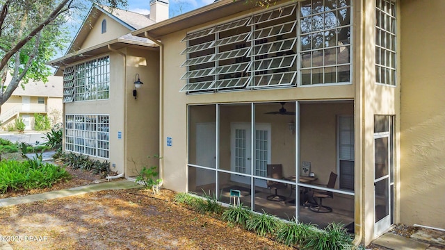 671 Wellington Station Blvd Unit 19, Ormond Beach, FL 32174 - view of side of property with stucco siding, a chimney, and a sunroom
