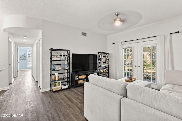 living area with baseboards, visible vents, dark wood-style floors, ceiling fan, and french doors