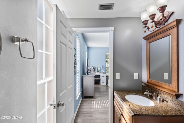 bathroom with visible vents, vanity, and wood finished floors