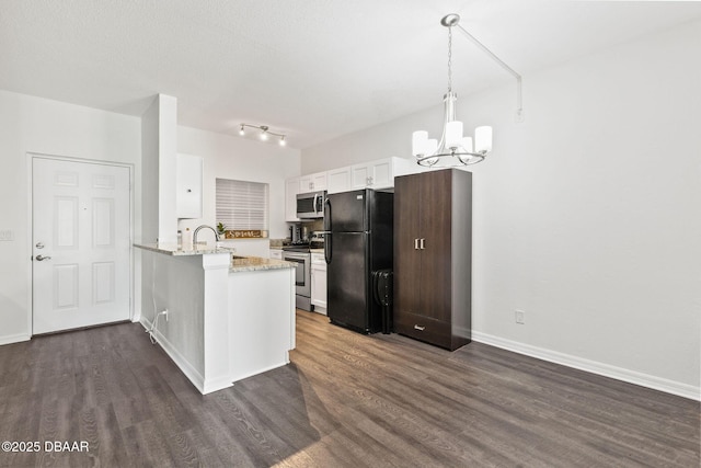 kitchen featuring a peninsula, appliances with stainless steel finishes, dark wood-type flooring, and an inviting chandelier