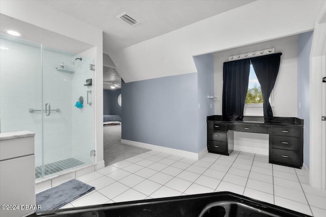 bathroom with vaulted ceiling, a stall shower, baseboards, and tile patterned floors