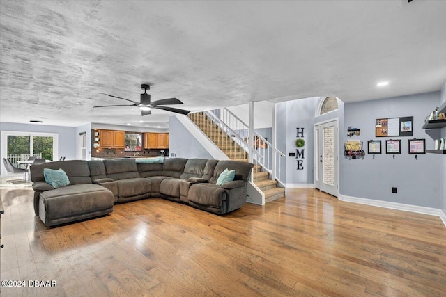 living area with baseboards, a ceiling fan, light wood-style flooring, stairway, and recessed lighting