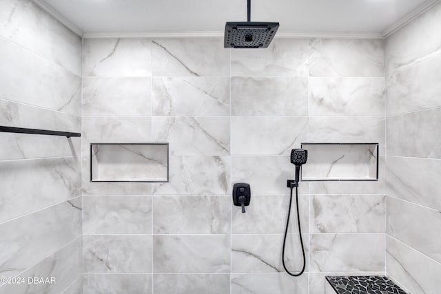 bathroom with ornamental molding and a tile shower