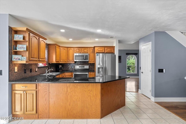 kitchen featuring stainless steel appliances, a peninsula, a sink, backsplash, and open shelves