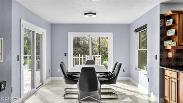 dining area featuring baseboards, light tile patterned floors, and a healthy amount of sunlight