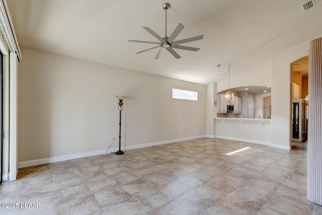 empty room featuring ceiling fan with notable chandelier