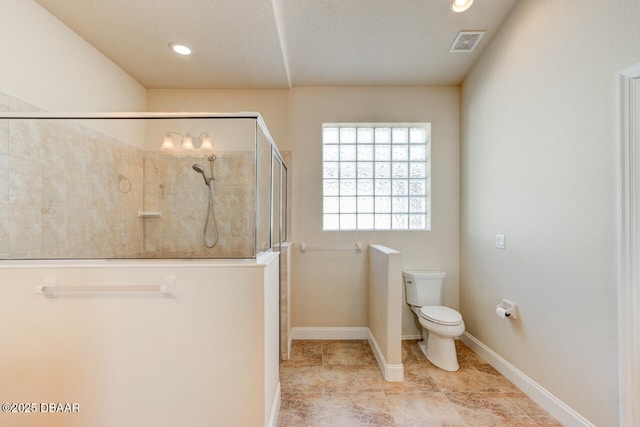 bathroom featuring tiled shower and toilet