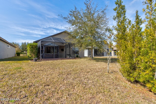 back of house featuring a lanai and a lawn