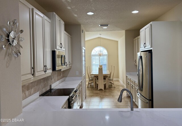 kitchen featuring appliances with stainless steel finishes, decorative light fixtures, sink, white cabinets, and light stone countertops