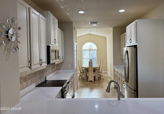 kitchen featuring light tile patterned floors, a textured ceiling, visible vents, appliances with stainless steel finishes, and pendant lighting