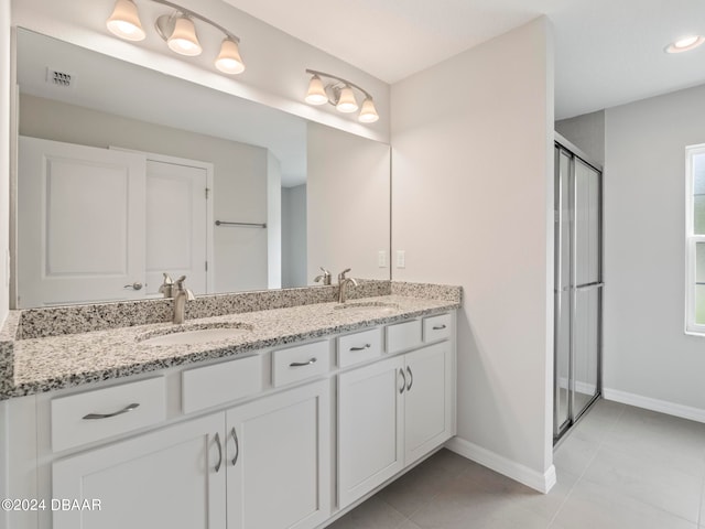 bathroom with an enclosed shower, vanity, and tile patterned floors