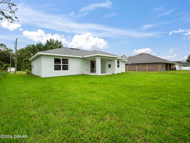 rear view of property featuring a lawn