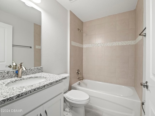 full bathroom featuring toilet, vanity, and tiled shower / bath