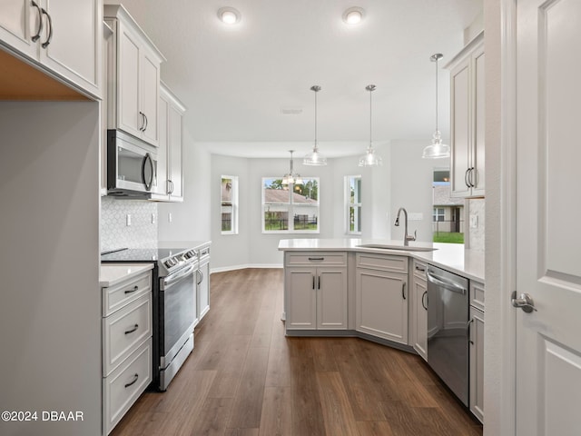 kitchen with stainless steel appliances, backsplash, dark hardwood / wood-style flooring, hanging light fixtures, and white cabinets