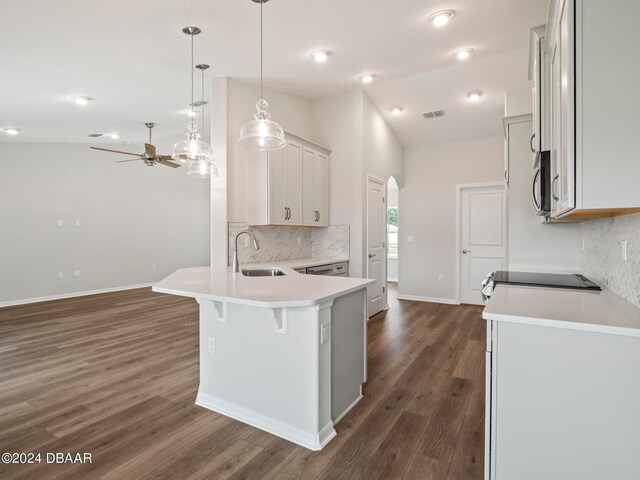 kitchen with hanging light fixtures, sink, dark wood-type flooring, and lofted ceiling