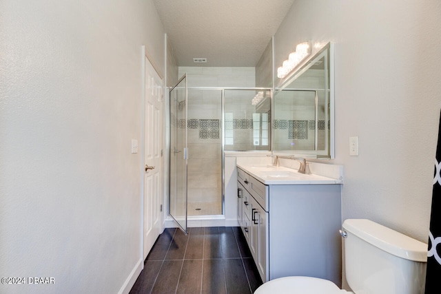 bathroom featuring walk in shower, vanity, tile patterned floors, and toilet