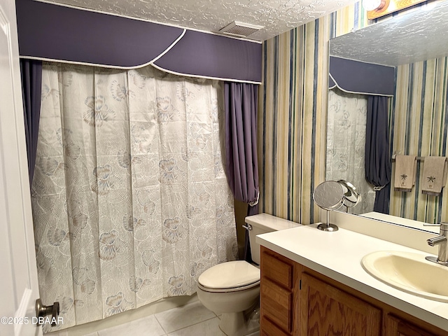 bathroom featuring toilet, vanity, a textured ceiling, and tile patterned floors