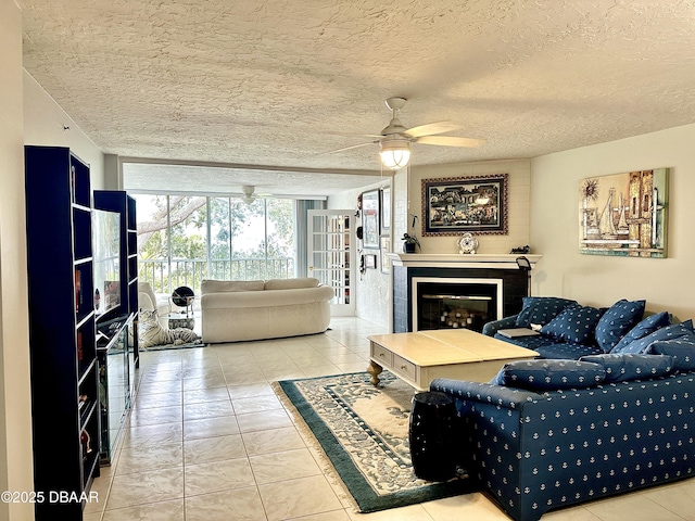 tiled living room featuring a textured ceiling, expansive windows, and ceiling fan