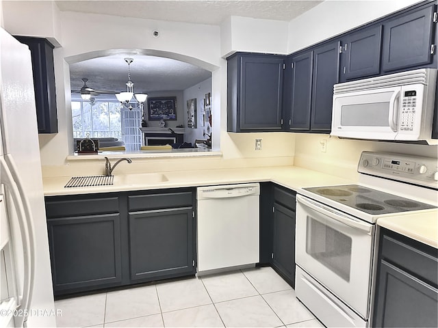 kitchen with white appliances, a textured ceiling, sink, pendant lighting, and light tile patterned flooring