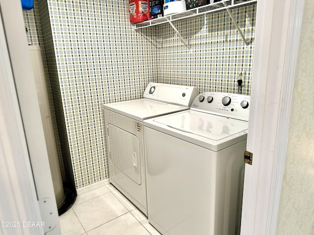 clothes washing area with washer and clothes dryer and light tile patterned floors