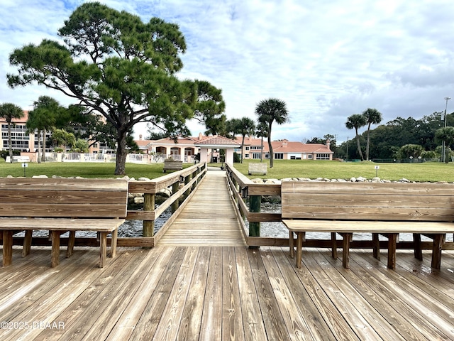 dock area featuring a water view and a lawn