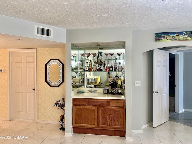 bar featuring sink and light tile patterned floors