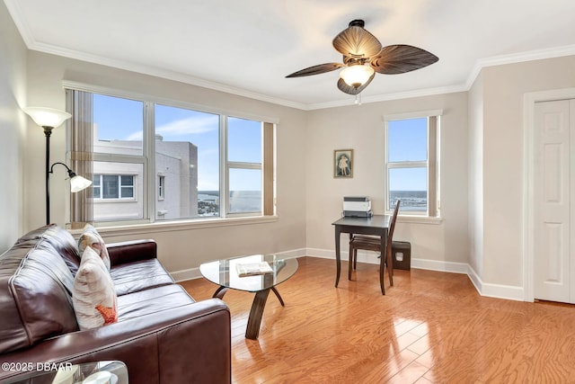 office area with light wood-type flooring, ceiling fan, and crown molding