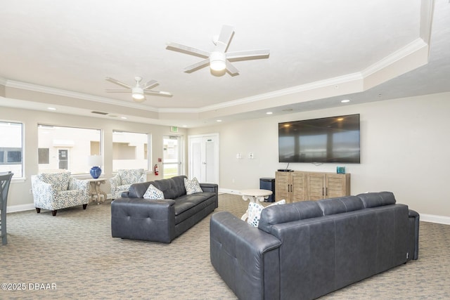 living room featuring crown molding, a wealth of natural light, and a tray ceiling