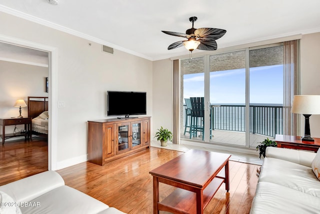 living room with crown molding, light wood-type flooring, and ceiling fan