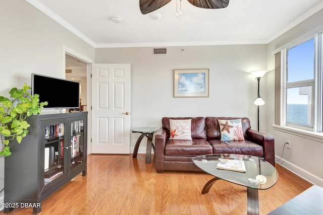 living room featuring light hardwood / wood-style flooring, a healthy amount of sunlight, and crown molding