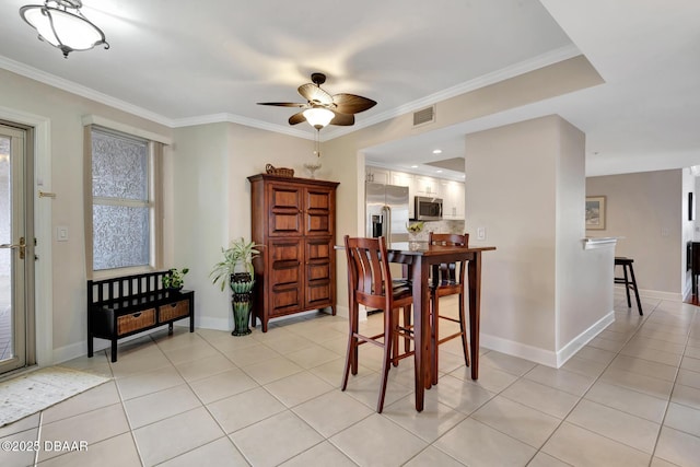 dining area with ceiling fan, ornamental molding, and light tile patterned floors