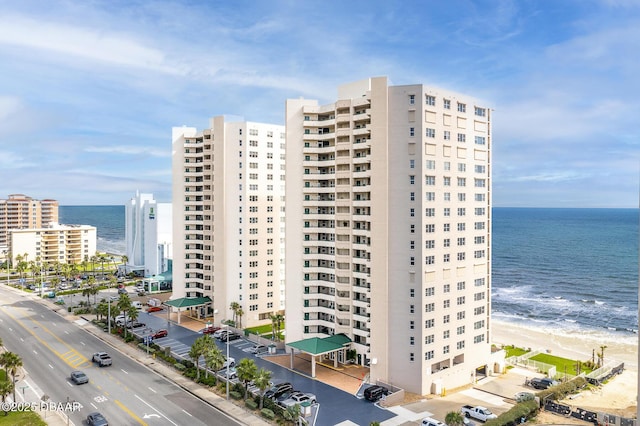 view of building exterior with a water view and a view of the beach