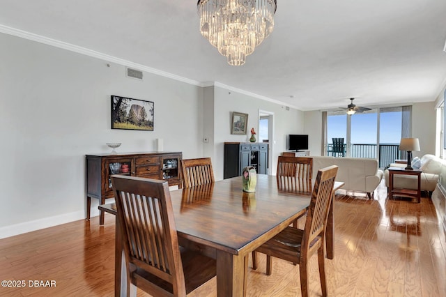 dining area with ceiling fan with notable chandelier, crown molding, and light hardwood / wood-style floors