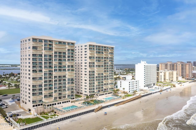 view of building exterior featuring a water view and a view of the beach