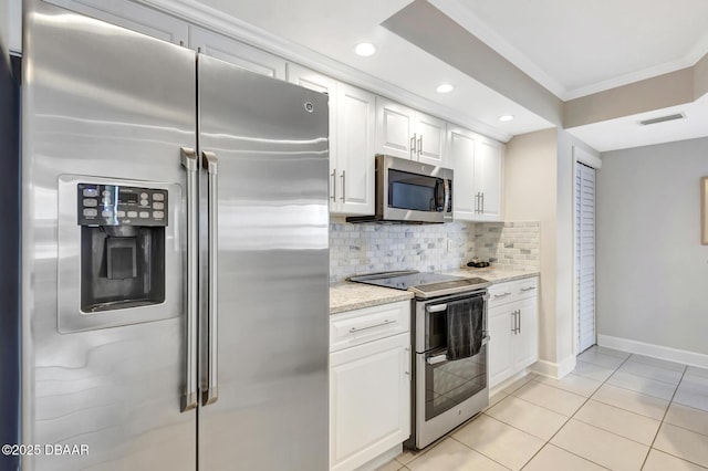 kitchen featuring appliances with stainless steel finishes, tasteful backsplash, white cabinetry, light tile patterned floors, and light stone counters