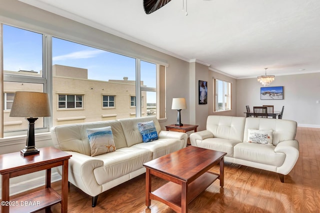 living room featuring hardwood / wood-style floors, a notable chandelier, and ornamental molding