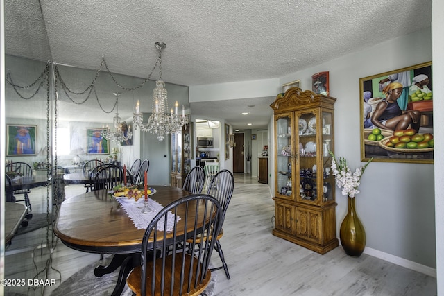 dining space with light hardwood / wood-style flooring and a textured ceiling