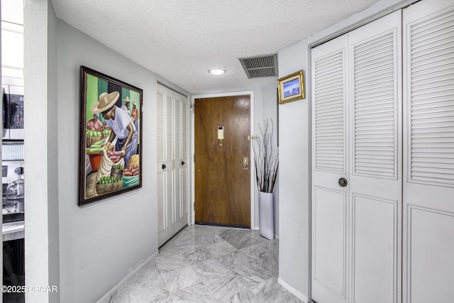 hallway with a textured ceiling