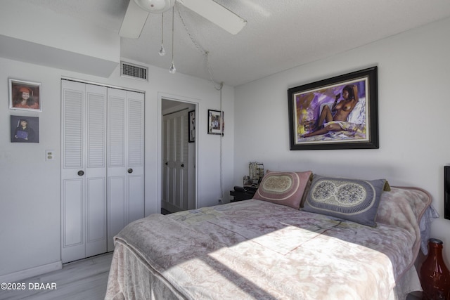 bedroom with a closet, ceiling fan, and light wood-type flooring