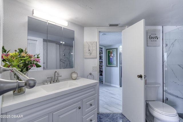 bathroom with vanity, toilet, and walk in shower